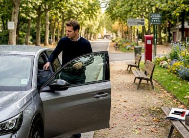 1778448709958_Automobiliste-rangeant-sac-dans-voiture-vitres-teintees Un conducteur range son sac à l’intérieur de sa voiture équipée de vitres teintées.