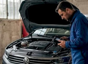 Un technicien spécialisé en GNV procède à un contrôle minutieux du moteur dans un atelier équipé.