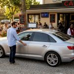 Une voiture récente aux vitres surteintées garée sur un parking.