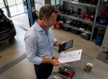 Un responsable de parc automobile en train d’examiner les dossiers d’entretien des véhicules.
