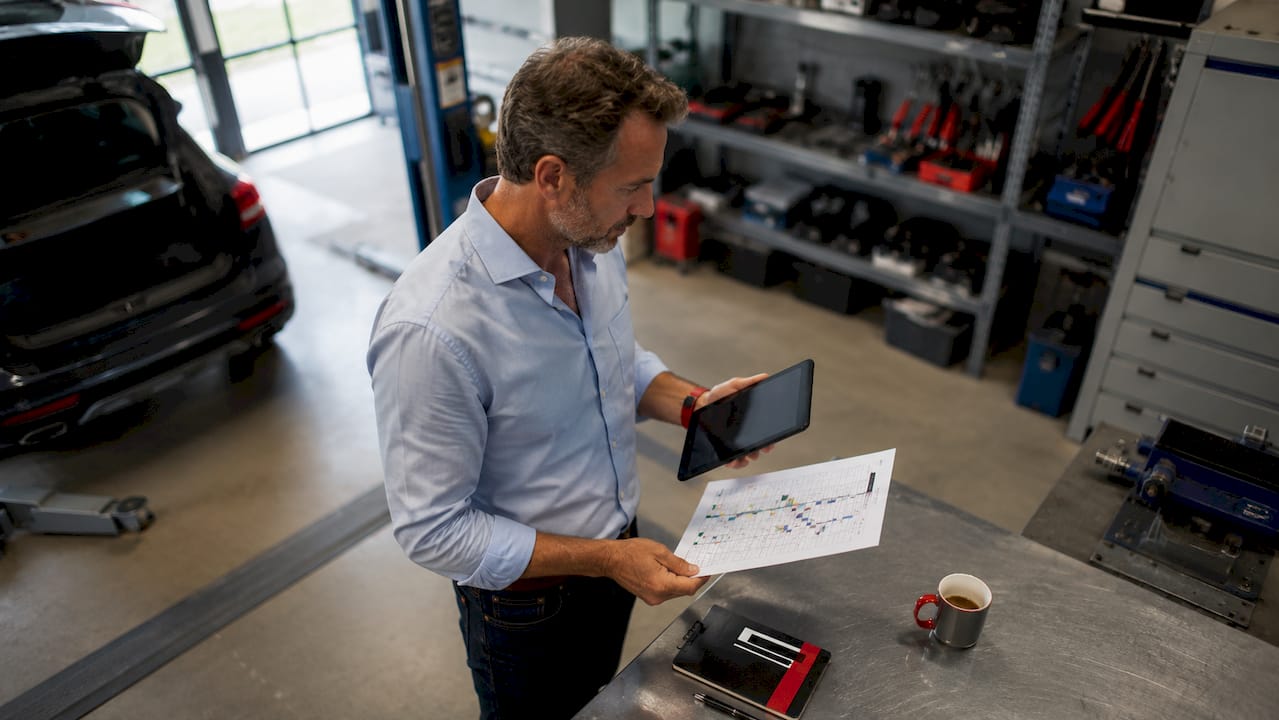 Un responsable de parc automobile en train d’examiner les dossiers d’entretien des véhicules.