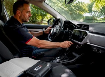 1781849229334_Conducteur-regle-climatisation-voiture-stationnee Un automobiliste ajuste la climatisation de sa voiture à l’arrêt.