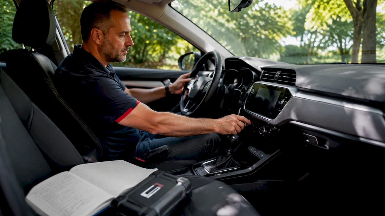 Un automobiliste ajuste la climatisation de sa voiture à l’arrêt.