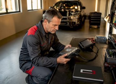 Un technicien est en train d’intervenir sur une boîte de vitesses dans l’atelier.