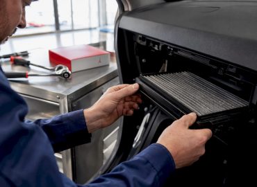 Un technicien procède au remplacement du filtre à pollen dans l’habitacle d’une voiture.