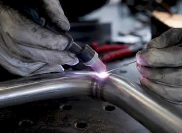 1786428747664_Hands-welding-stainless-steel-TIG-arc-close-up Gros plan sur des mains en train de souder de l’acier inoxydable avec un procédé TIG