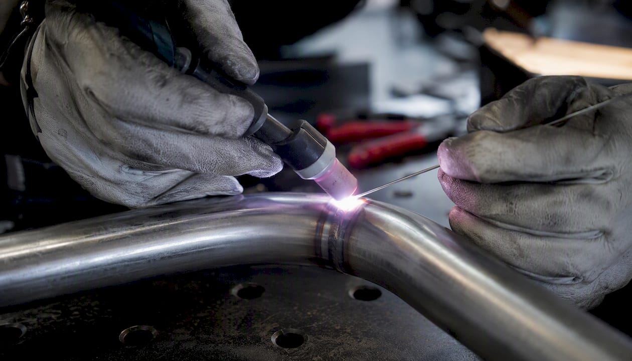 Gros plan sur des mains en train de souder de l’acier inoxydable avec un procédé TIG
