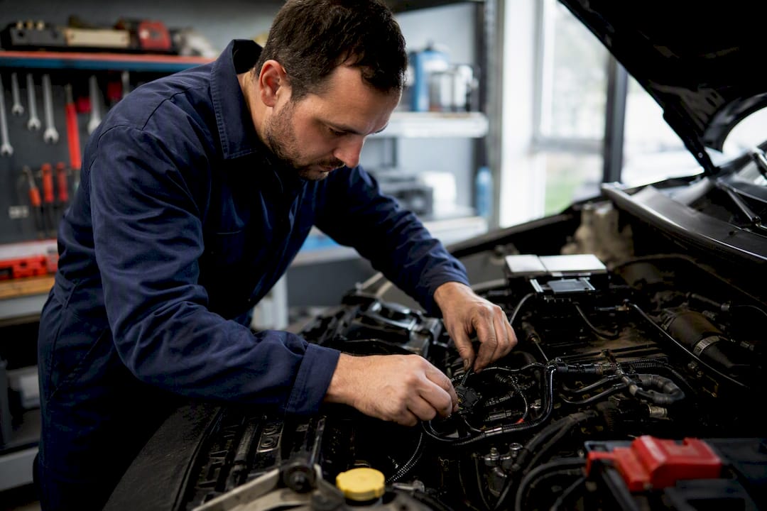 Technicien installant un kit de conversion E85 sur un moteur