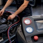 Technicien vérifiant un circuit de climatisation automobile